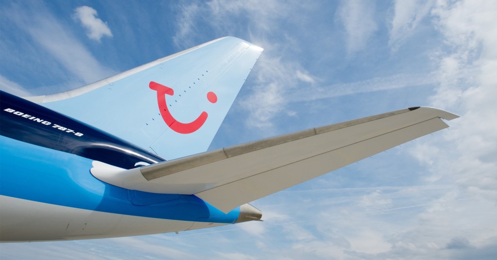 TUI airplane wing pictured against the backdrop of blue sky. 