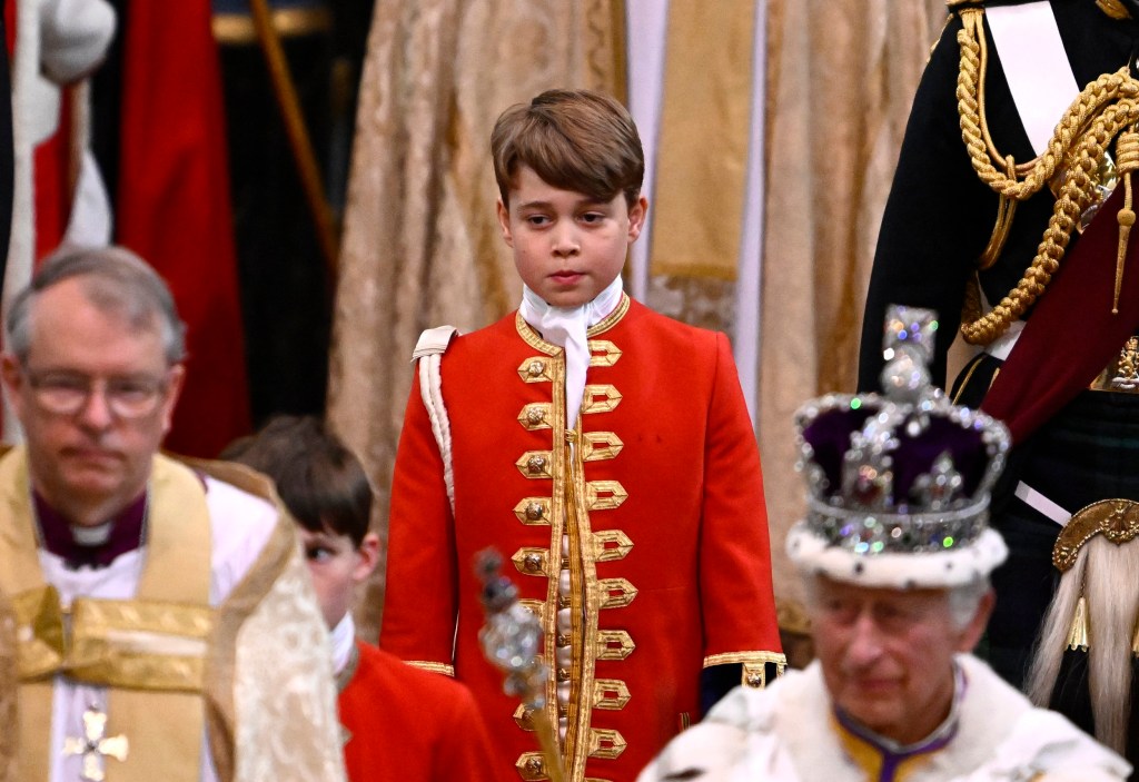 Page of Honour Prince George of Wales and Britain's King Charles III wearing the Imperial state Crown leave Westminster Abbey after the Coronation Ceremonies in central London