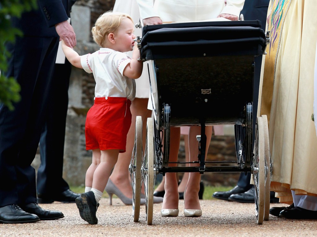  Prince George looks at his sister Princess Charlotte in her pram as he leaves the Church of St Mary Magdalene on the Sandringham Estate